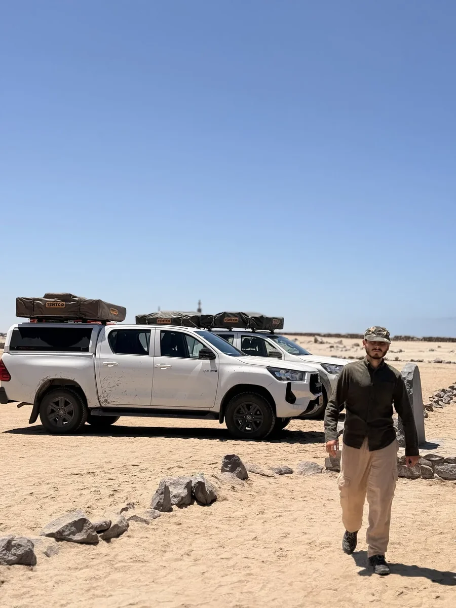 Aniello accanto ai due Toyota Hilux 4x4 con tende da tetto, in Namibia